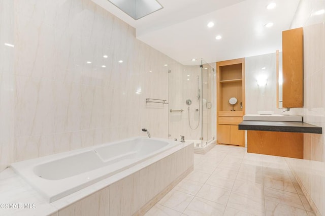 bathroom with vanity, separate shower and tub, and tile walls