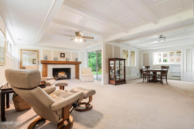 living room featuring ceiling fan, a wealth of natural light, beamed ceiling, and carpet flooring