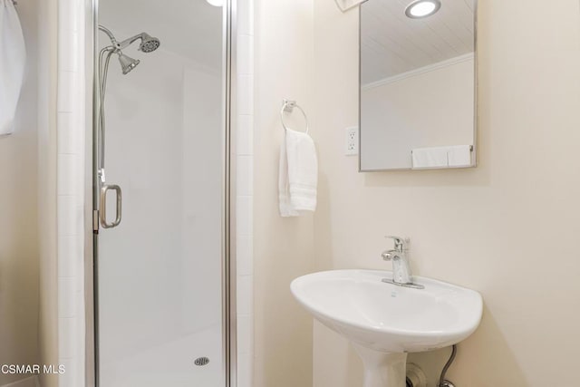 bathroom featuring sink and a shower with door