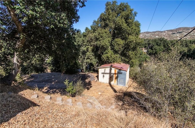 view of yard featuring a shed and a mountain view