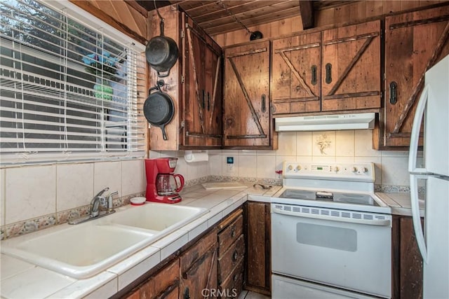 kitchen with white appliances, tile countertops, sink, and decorative backsplash