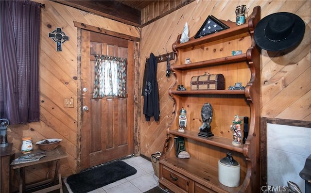 entryway with light tile patterned floors and wooden walls