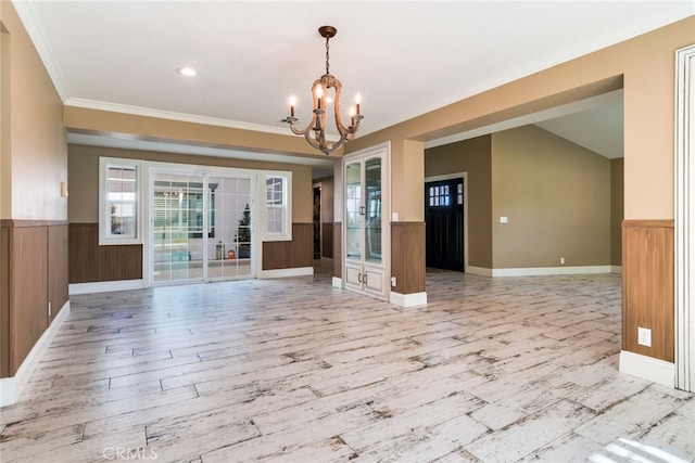 interior space with light hardwood / wood-style flooring, an inviting chandelier, and crown molding