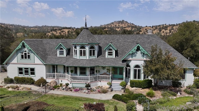 victorian house with a mountain view and a porch