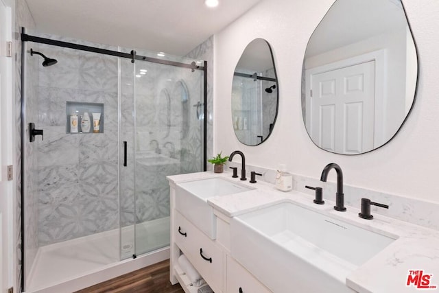 bathroom with wood-type flooring, vanity, and an enclosed shower