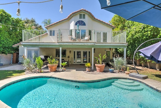 back of property featuring a patio area, french doors, and a balcony