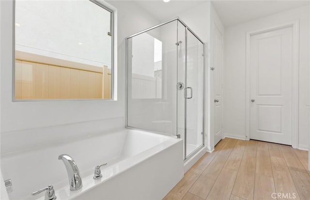 bathroom featuring hardwood / wood-style floors and separate shower and tub