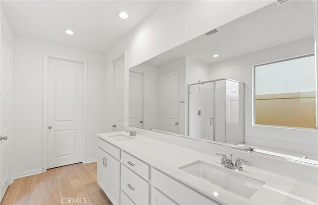 bathroom featuring vanity, wood-type flooring, and walk in shower