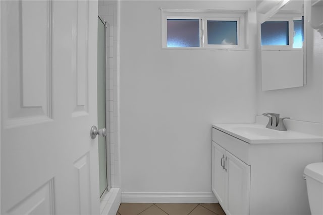 bathroom featuring toilet, vanity, baseboards, tile patterned floors, and a stall shower