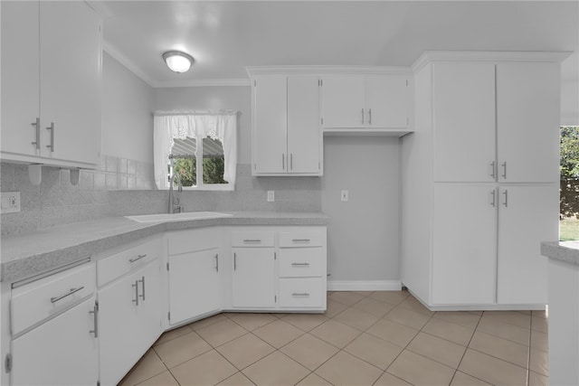 kitchen with backsplash, sink, crown molding, and white cabinetry