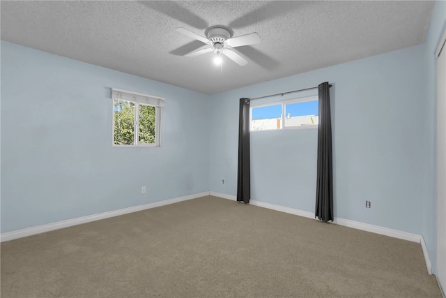 empty room featuring carpet floors, a wealth of natural light, ceiling fan, and baseboards