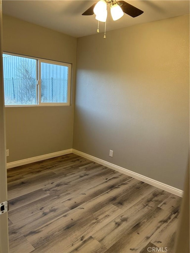 spare room with hardwood / wood-style flooring and ceiling fan