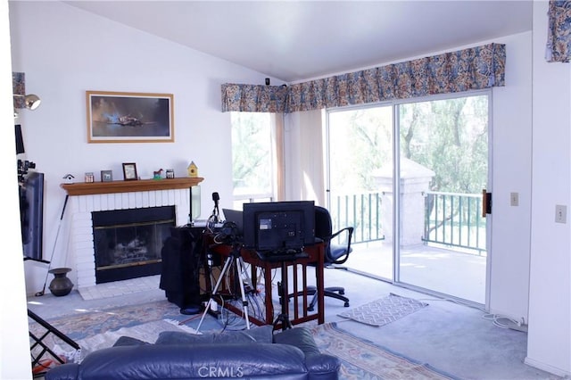 carpeted living room with lofted ceiling and a brick fireplace