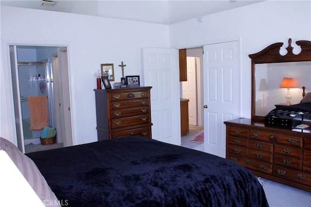 bedroom featuring light colored carpet and ensuite bath