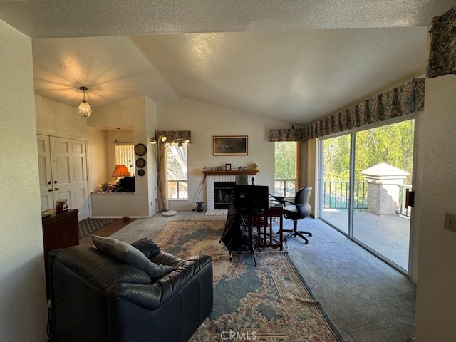 carpeted living room with a brick fireplace, a textured ceiling, vaulted ceiling, and a wealth of natural light