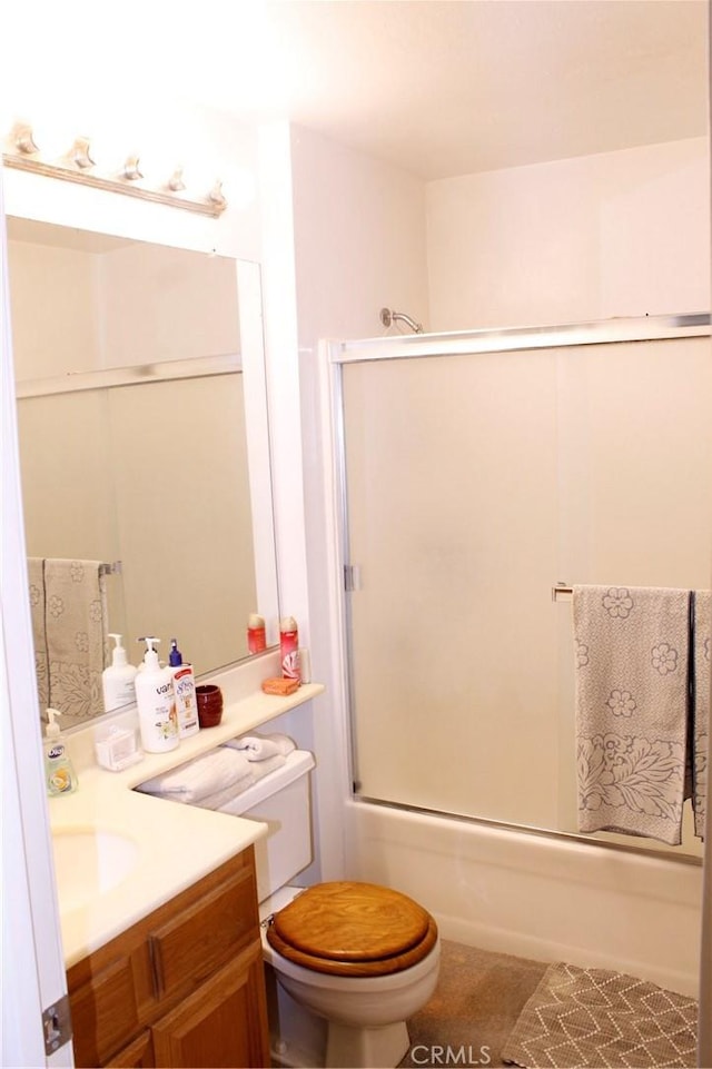 full bathroom with combined bath / shower with glass door, vanity, toilet, and tile patterned flooring