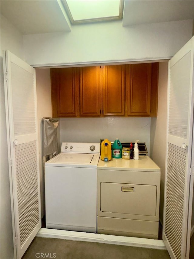 clothes washing area featuring cabinets and independent washer and dryer