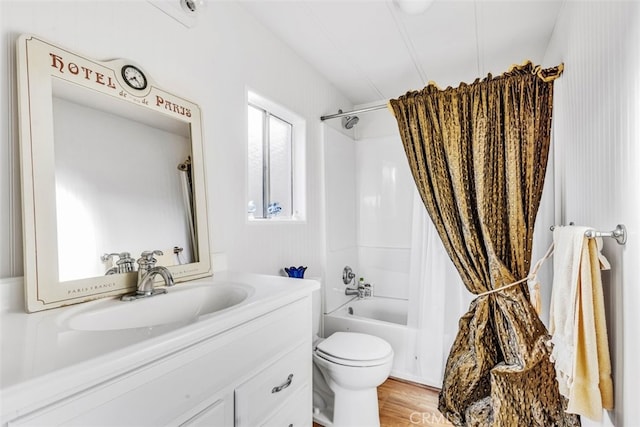 full bathroom featuring toilet, shower / bathtub combination with curtain, hardwood / wood-style flooring, and vanity