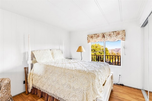 bedroom with a closet, light hardwood / wood-style flooring, and access to outside