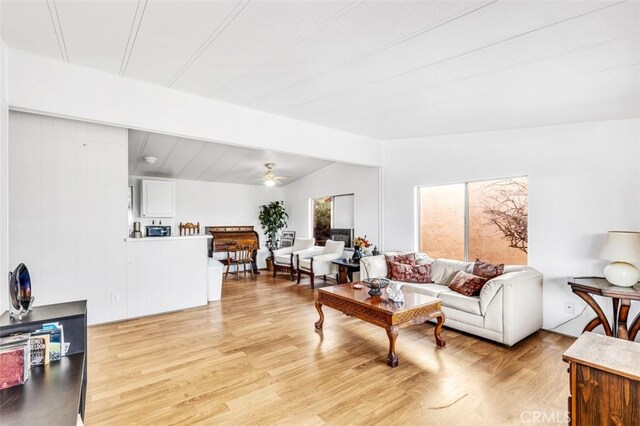 living room with ceiling fan, lofted ceiling, and light hardwood / wood-style flooring