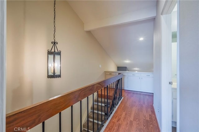 corridor with hardwood / wood-style floors and lofted ceiling