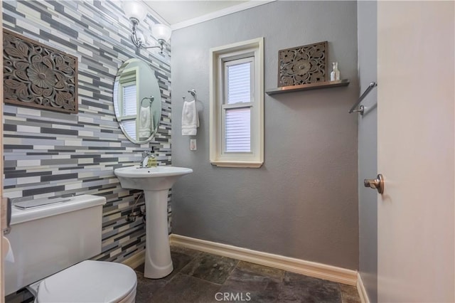 bathroom with decorative backsplash, crown molding, and toilet