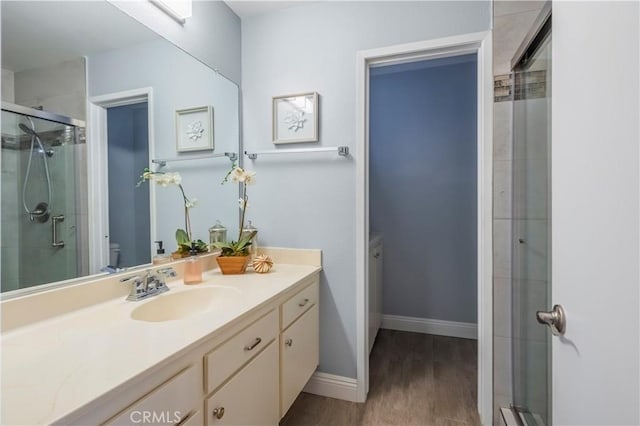 bathroom featuring vanity, toilet, wood-type flooring, and walk in shower