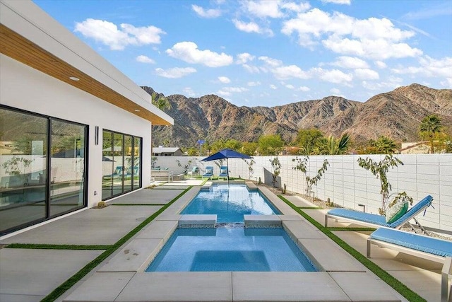 view of pool with a mountain view, a patio, and an in ground hot tub