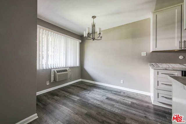 unfurnished dining area with a chandelier, dark hardwood / wood-style flooring, and a wall mounted AC