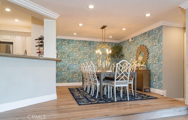 dining space featuring an inviting chandelier, light wood-type flooring, and ornamental molding