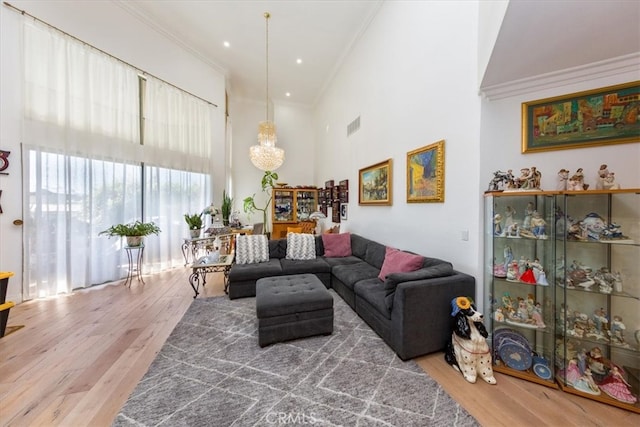 living room featuring ornamental molding, a chandelier, and hardwood / wood-style floors