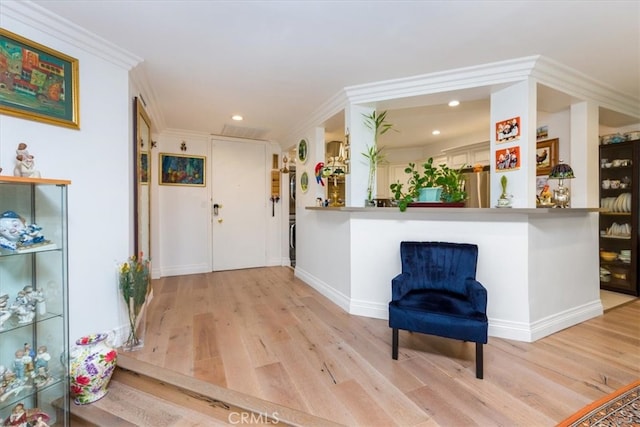 entryway with light hardwood / wood-style flooring and ornamental molding