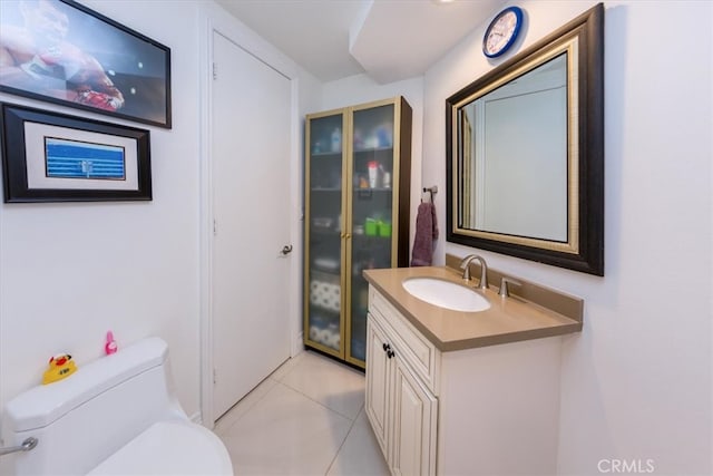 bathroom featuring tile patterned flooring, vanity, and toilet