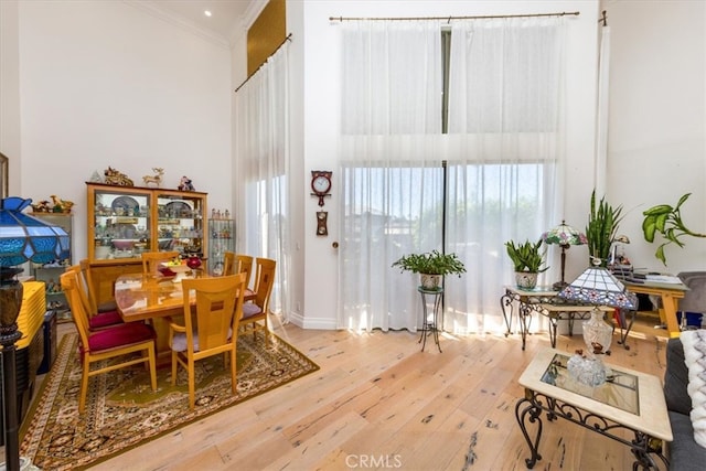 dining space with hardwood / wood-style flooring, crown molding, and plenty of natural light