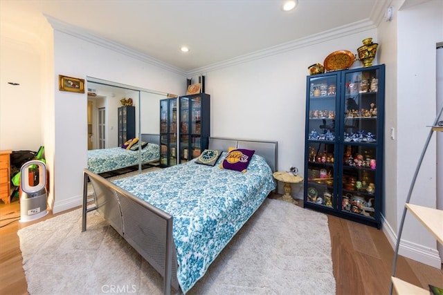 bedroom with light hardwood / wood-style flooring, a closet, and ornamental molding