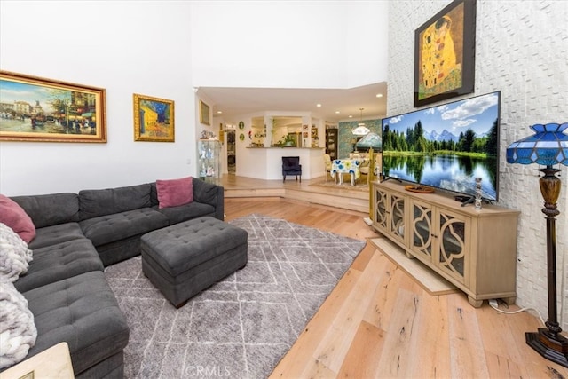 living room with a towering ceiling and hardwood / wood-style floors