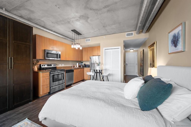 bedroom with dark hardwood / wood-style floors and stainless steel fridge