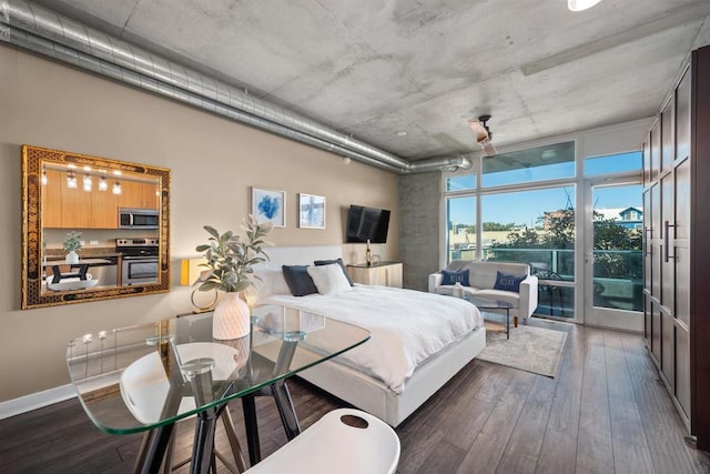 bedroom featuring access to exterior and dark wood-type flooring