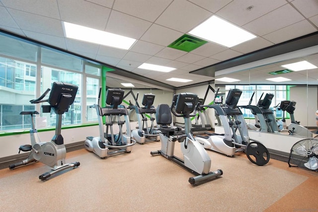 workout area featuring a drop ceiling and plenty of natural light