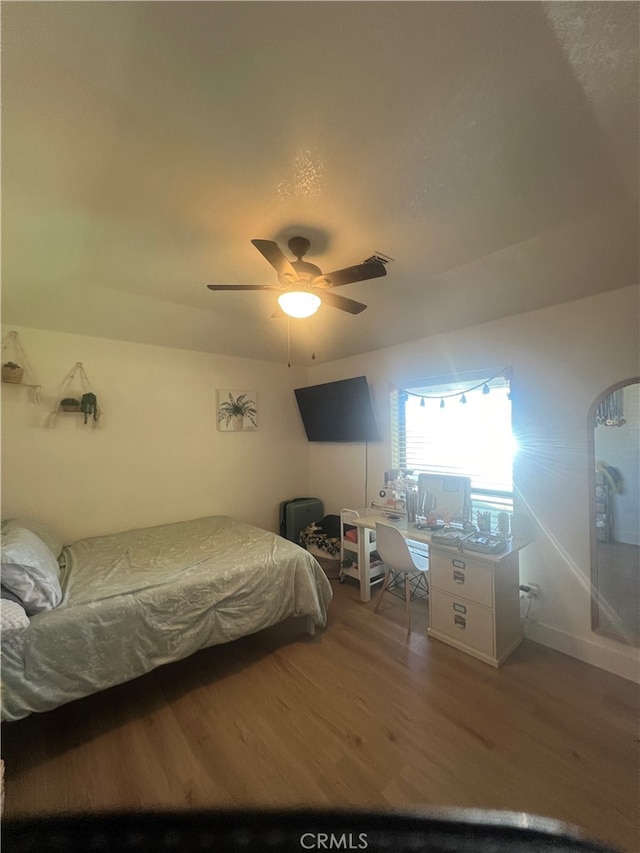 bedroom with ceiling fan and hardwood / wood-style flooring