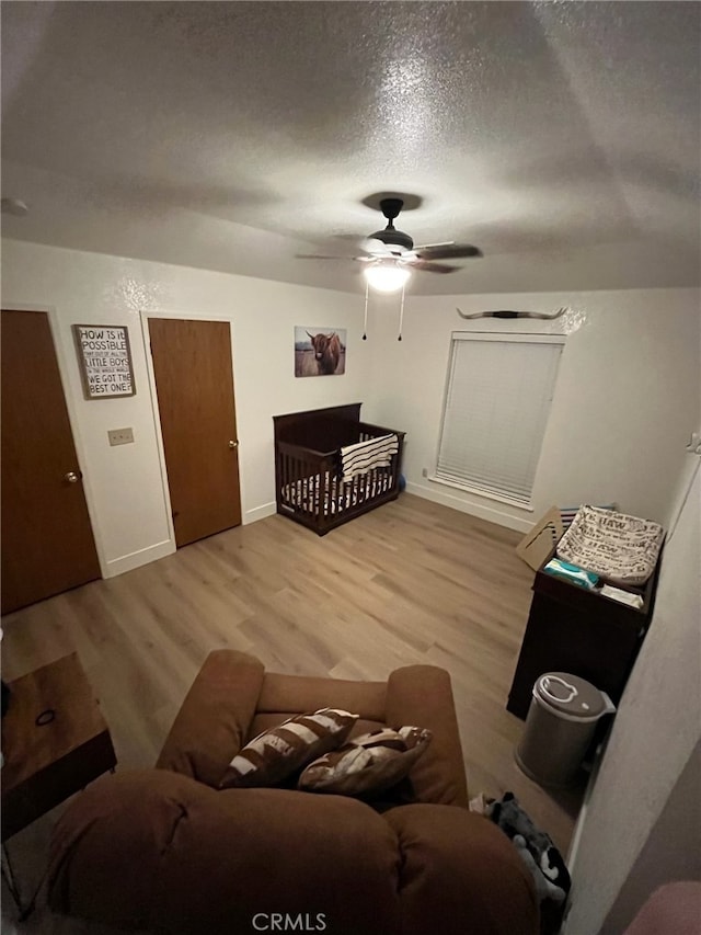 living room featuring a textured ceiling, hardwood / wood-style floors, and ceiling fan