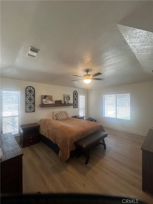 bedroom featuring ceiling fan, a textured ceiling, and hardwood / wood-style floors