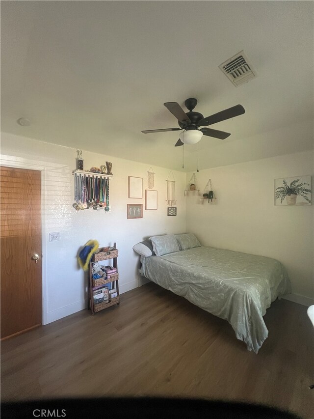 unfurnished bedroom featuring ceiling fan and dark hardwood / wood-style flooring