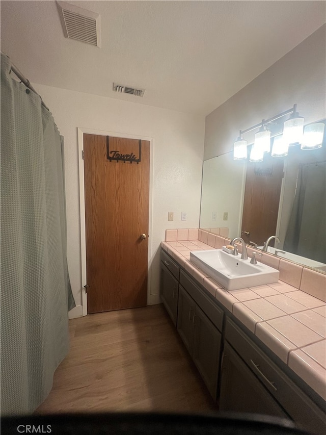 bathroom with a shower with shower curtain, vanity, and hardwood / wood-style flooring