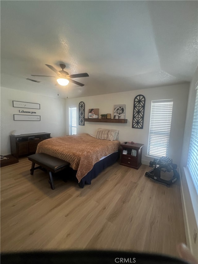 bedroom featuring ceiling fan, a textured ceiling, and wood-type flooring