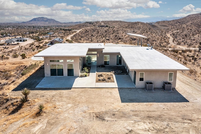 back of house featuring cooling unit, a mountain view, and a patio area