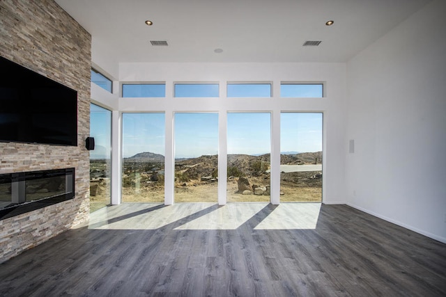 unfurnished living room featuring a mountain view, hardwood / wood-style flooring, and a fireplace