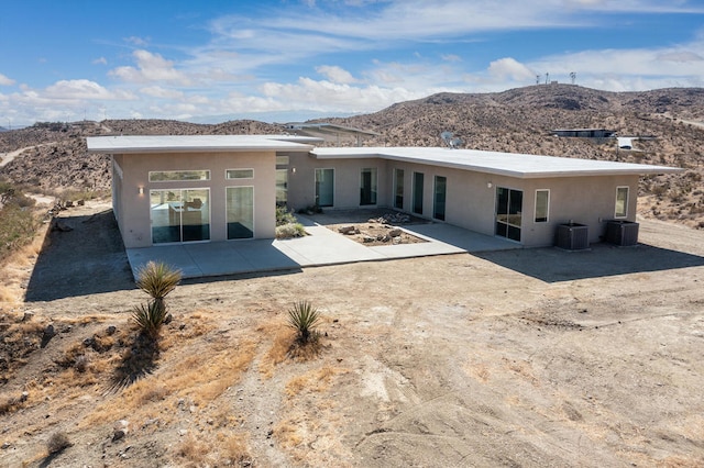 back of house with cooling unit, a mountain view, and a patio area