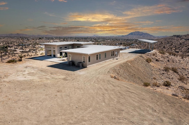 view of front facade featuring a mountain view, a patio area, and central air condition unit