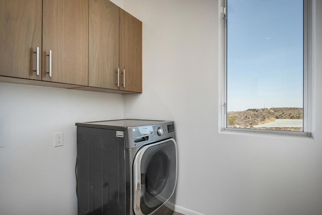 laundry area featuring washer / clothes dryer and cabinets